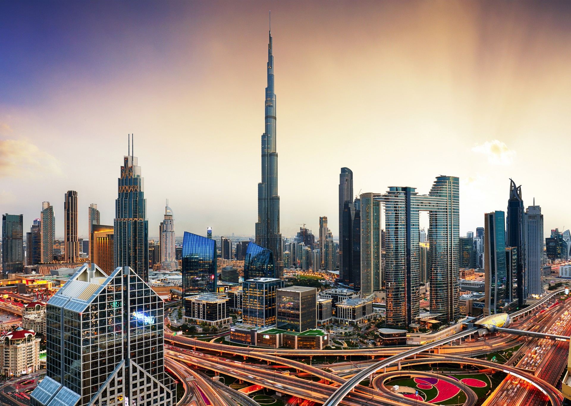 Skyline of Dubai bussines downtown at sunset with sun, United Arab Emirates